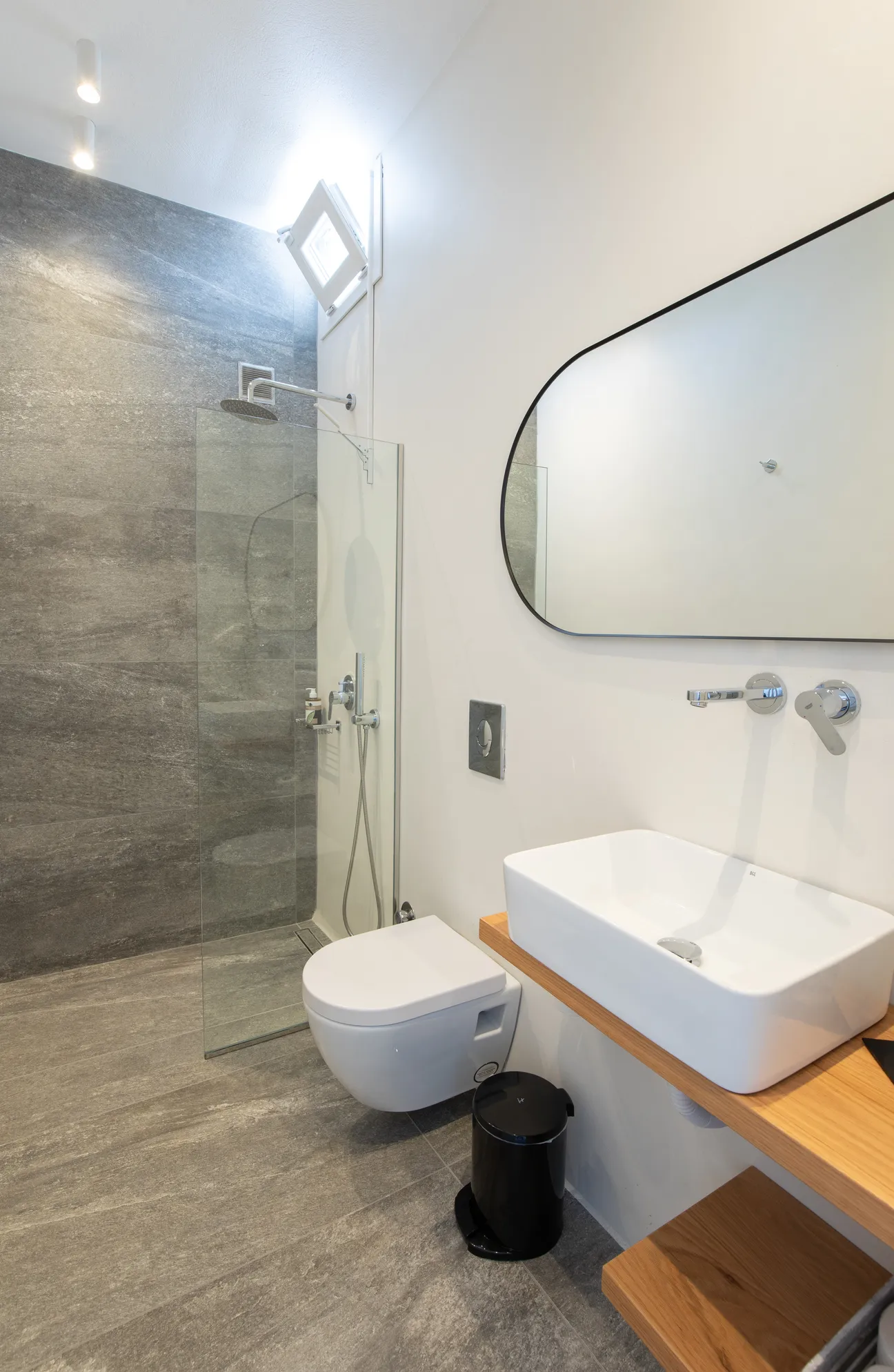 Bathroom with walk-in shower and oval mirror